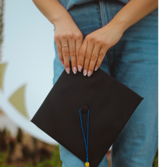 Student holds a mortarboard