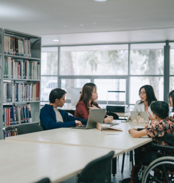 Student with disabilities is studying together with a tutor and other students