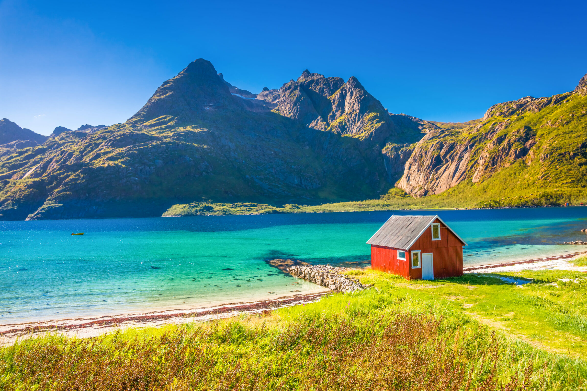 Spiaggia scandinava con acqua turchese e montagne